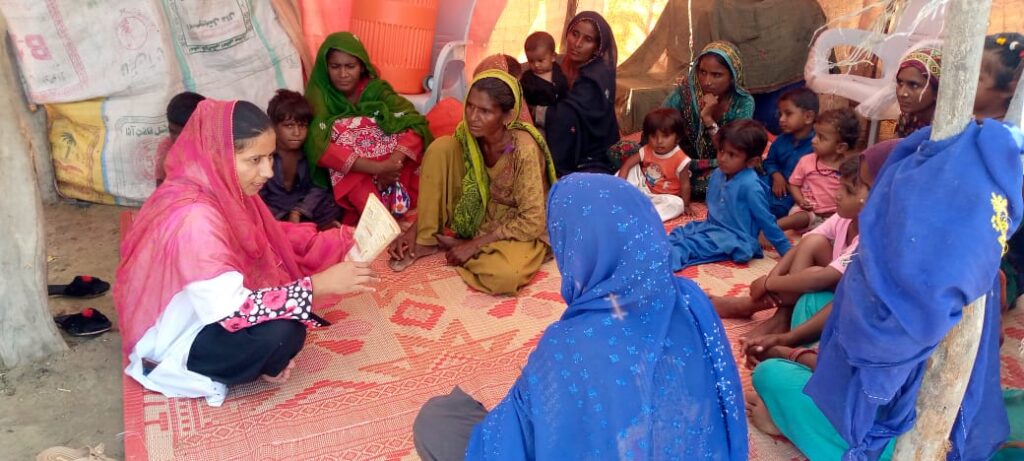 A female health worker shares information on preventive diseases and hygiene practices following massive flooding.