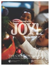 Picture of a child putting an ornament on a Christmas tree with the words, "Overwhelmed with Joy!: The Christmas Fund"