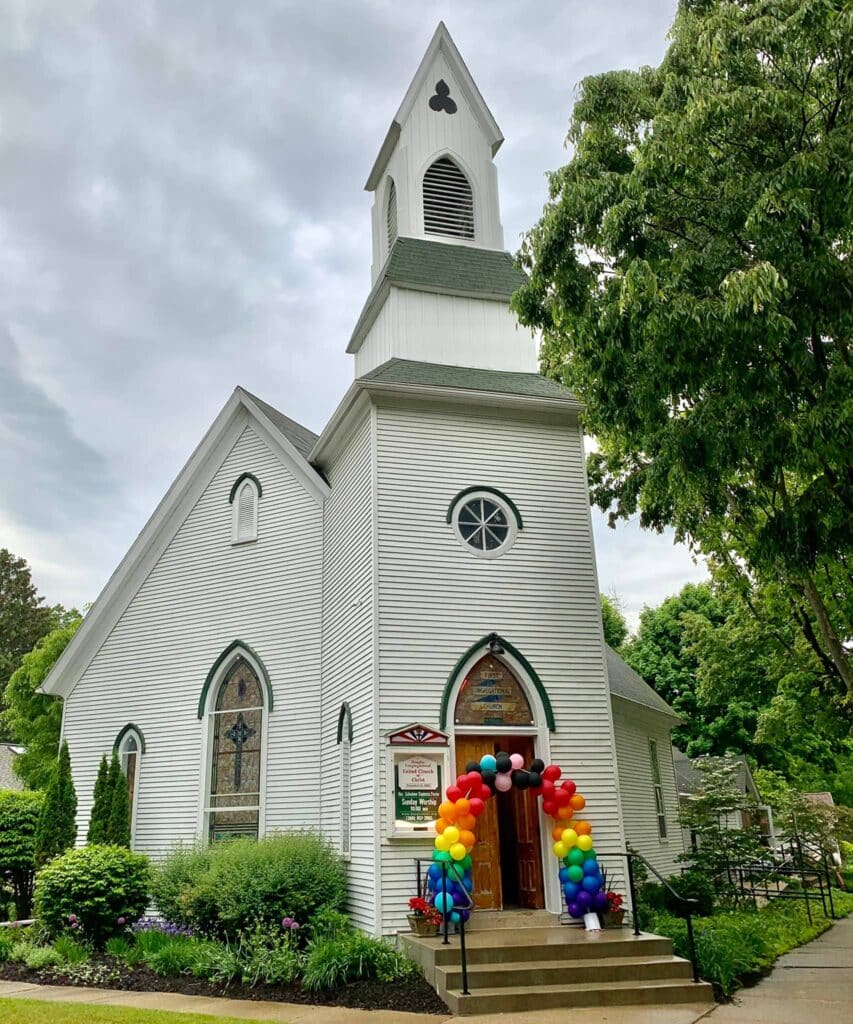 Rainbow balloons surround church entrance
