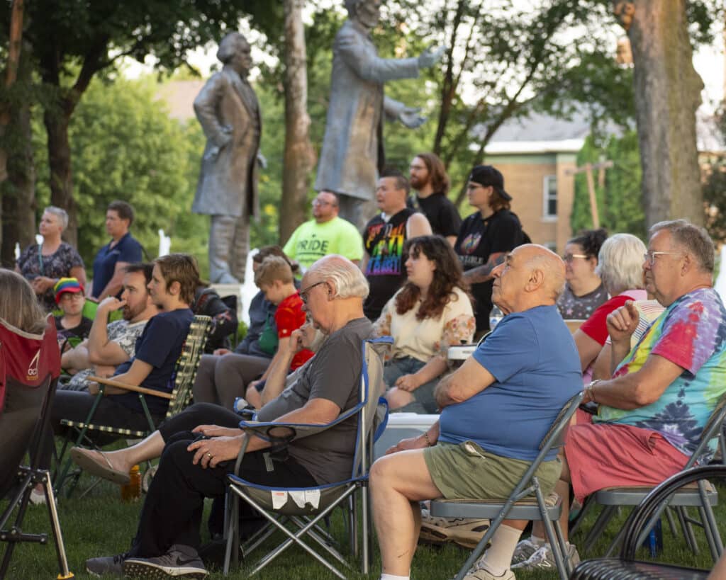 People sit in chairs in Washington Park.