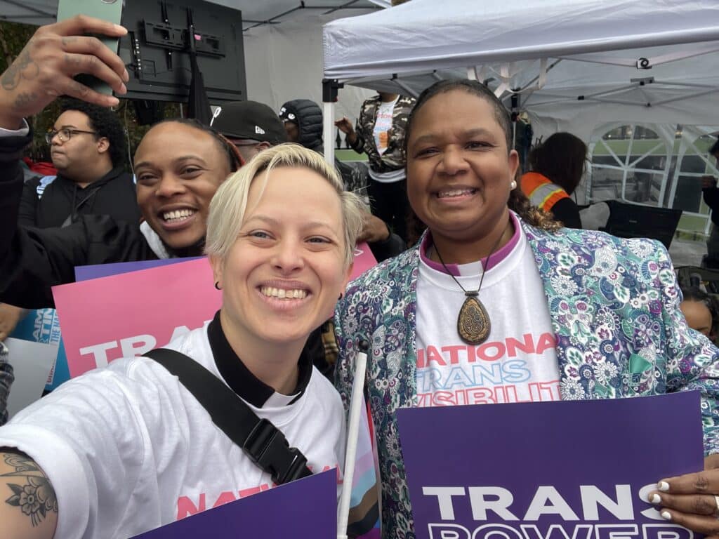 UCC leaders hold signs during Trans Visibility March.