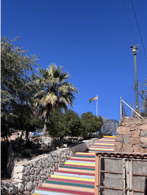 A rainbow-striped Pride flag is seen at the top of rainbow-painted steps