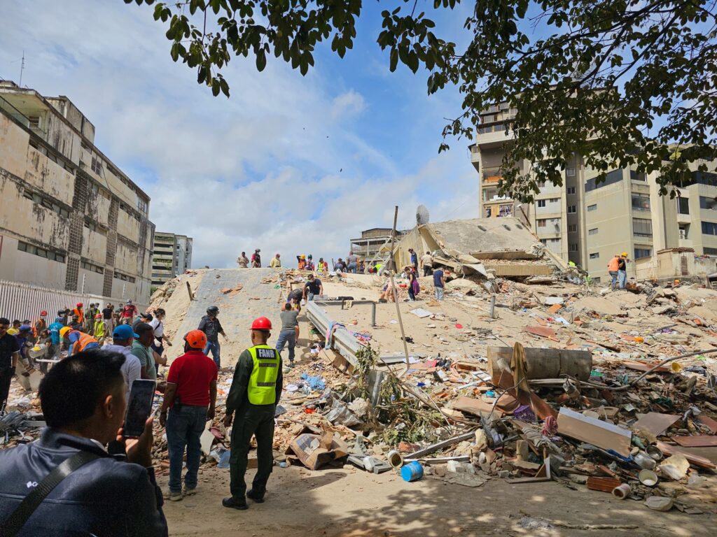 Image of people standing in front of rubble after an earthquake hit Venezuala