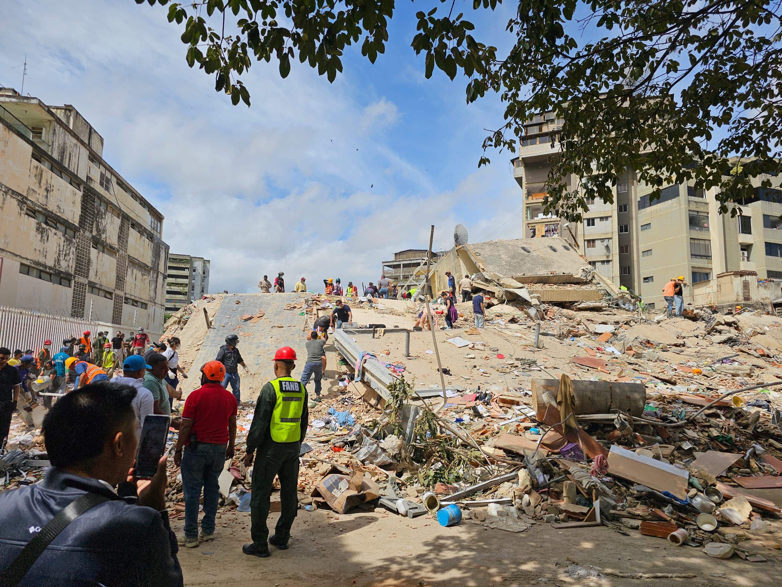 Image of people standing in front of rubble after an earthquake hit Venezuala