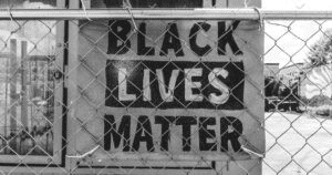 Black Lives Matter sign affixed to a metal fence
